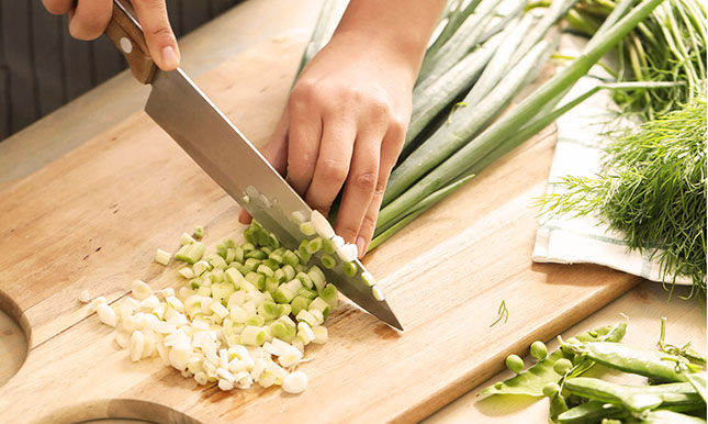 Préparation d'un oignon long frais, populaire en Asie, pour la préparation de nos plats.